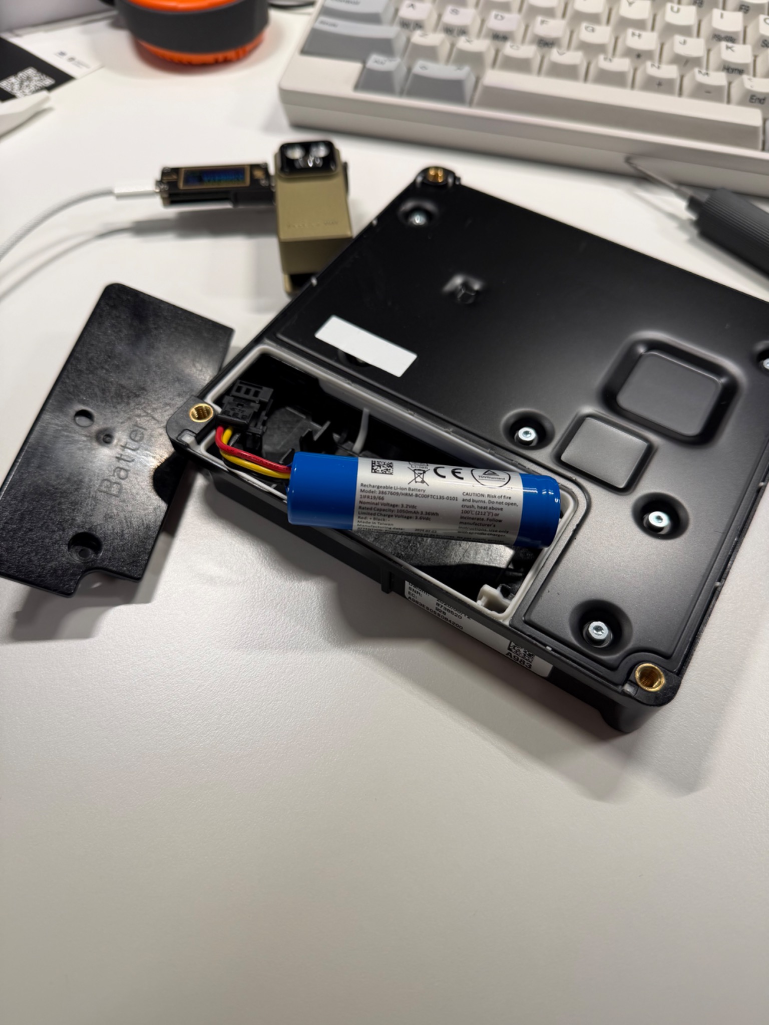 SOS module backup battery exposed on a work desk