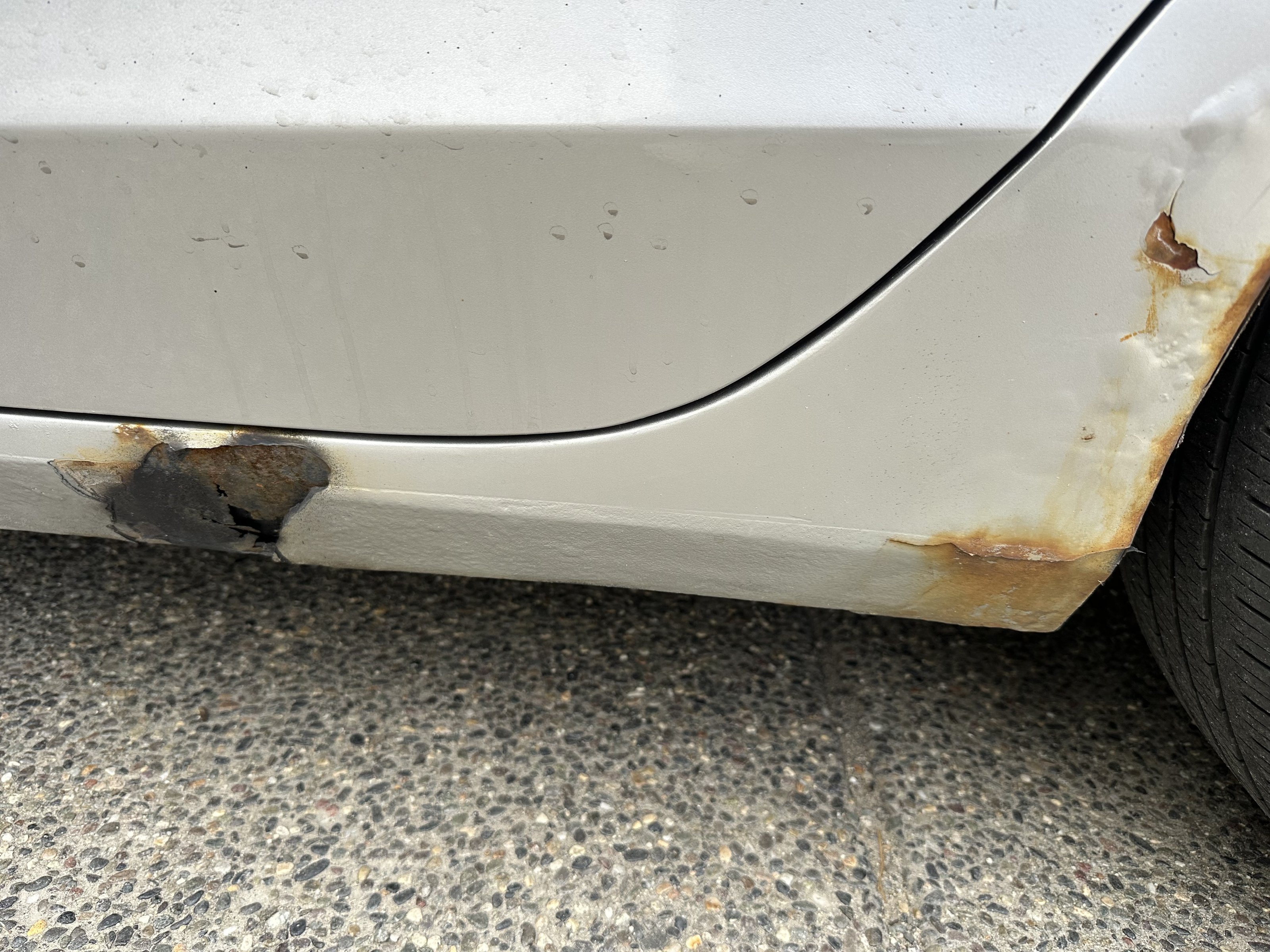 Rust along the lower body and rear wheel arch of the Audi